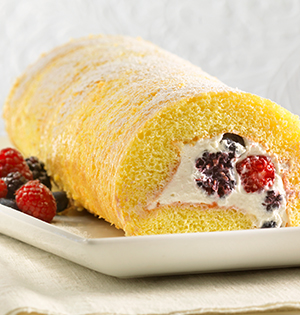 Fruit Salad Roll Cake on a serving dish with assorted berries