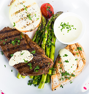 Delicious Dijon Marinaded steak and chicken served with roasted onion, asparagus and cherry tomatoes and a dollap of Astro yogurt
