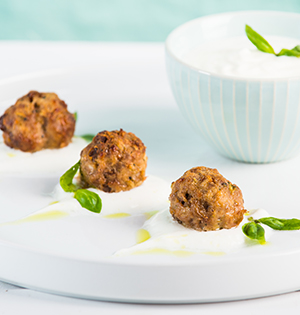 Mediterranean Lamb Meatballs with Astro Yogurt Tahini Sauce served on a white platter