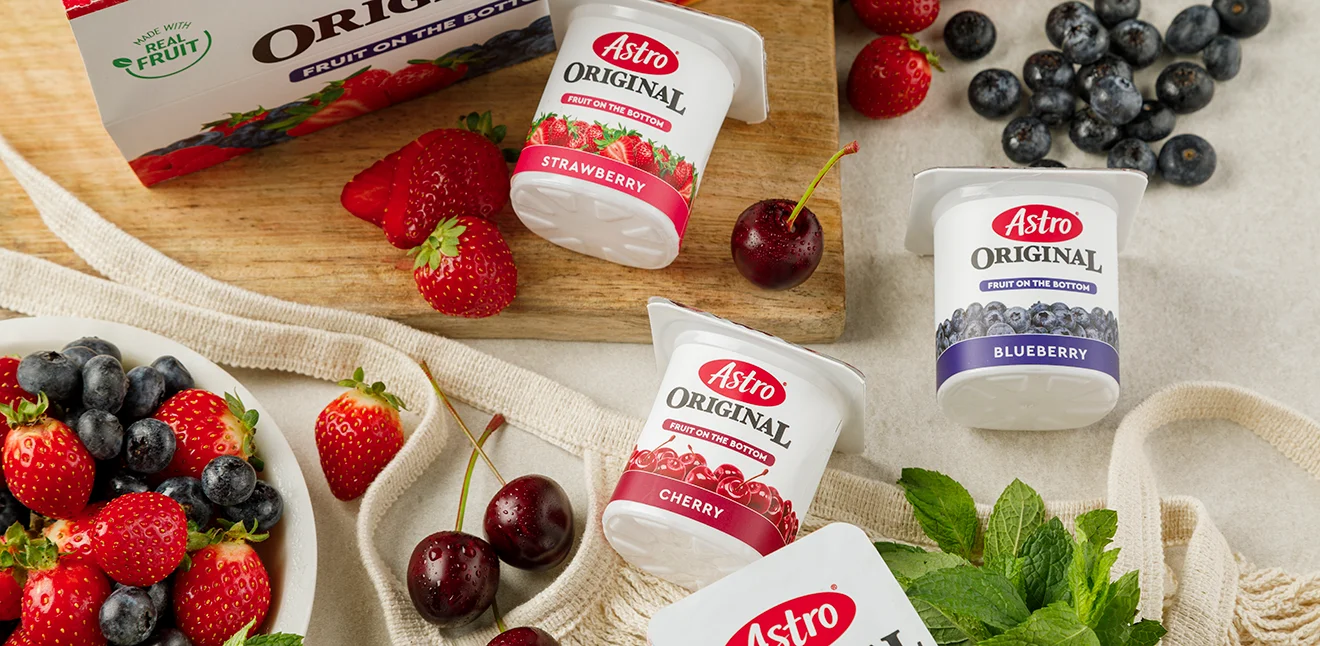 Astro Fruit on the bottom small tubs on a table with various fruit.